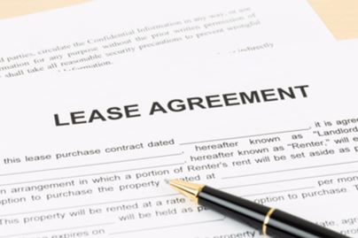 A Lease Agreement With A Pen On Top 